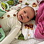 Paisley joined the competition — help win amazing prizes! baby, blanket, child, comfort, cozy, cute, face, grinch, happy, indoors, infant, lying_down, patterned_blanket, pink_blanket, portrait, smiling, soft_texture, warm, white_clothing, wooden_buttons