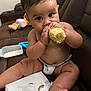 baby, diaper, corn, eating, couch, bottle, toy, napkin, milk, child, indoor, brown_couch, cute, messy, barefoot, chubby, infant, sitting, food, feeding