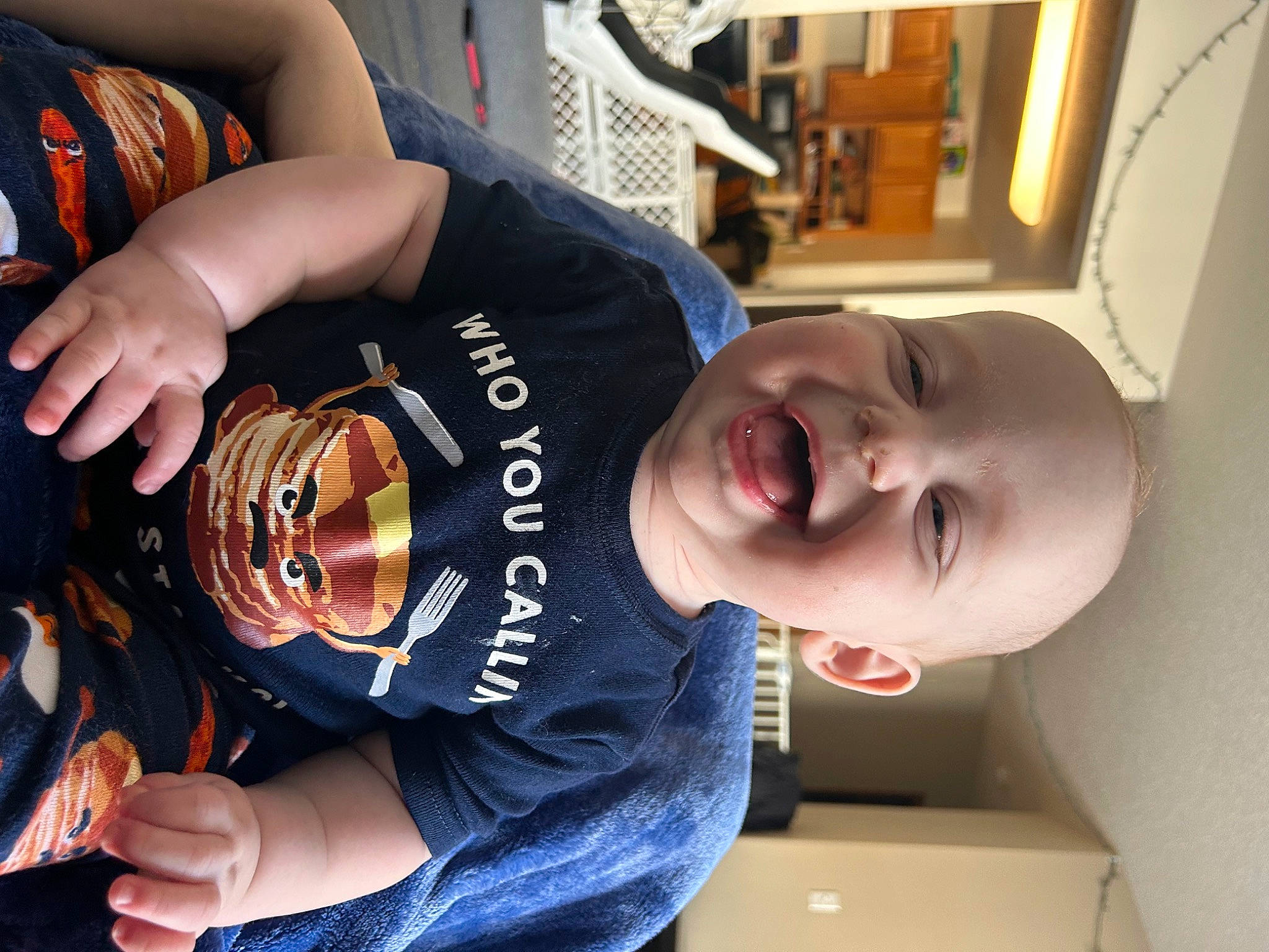 Cora is registered to the contest to win money with this photo: baby, baby_laughing, baby_toddler_clothing, child, cool, elbow, eyewear, finger, fun, happy, person, personal_protective_equipment, room, sleeve, smile, sports_uniform, t_shirt, toddler, wrist