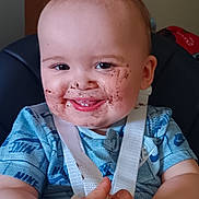 Reilly joined the competition — help win amazing prizes! baby, child, smiling, chocolate, face, hands, high_chair, blue_shirt, white_strap, happy, messy, indoor, person, infant, cute, young_child, seat, feeding_time, food, fun