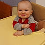 baby, child, high_chair, smiling, indoor, person, red_clothing, gray_clothing, wooden_chair, floor, happy, face, head, infant, sitting, hands, table, cute, young, portrait