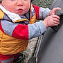 Reilly joined the competition — help win amazing prizes! toddler, child, hat, knitted_hat, vest, yellow_vest, climbing_wall, playground, outdoor, curious, hands, shoes, batman_logo, red_clothing, gray_clothing, face, expression, young_child, standing, play