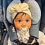 Liyana is registered to the contest to win money with this photo: baby, child, pacifier, car_seat, headband, bow, infant, face, wide_eyes, straps, clothing, indoor, seat_belt, cute, young_child, looking, person, adorable, baby_girl, closeup