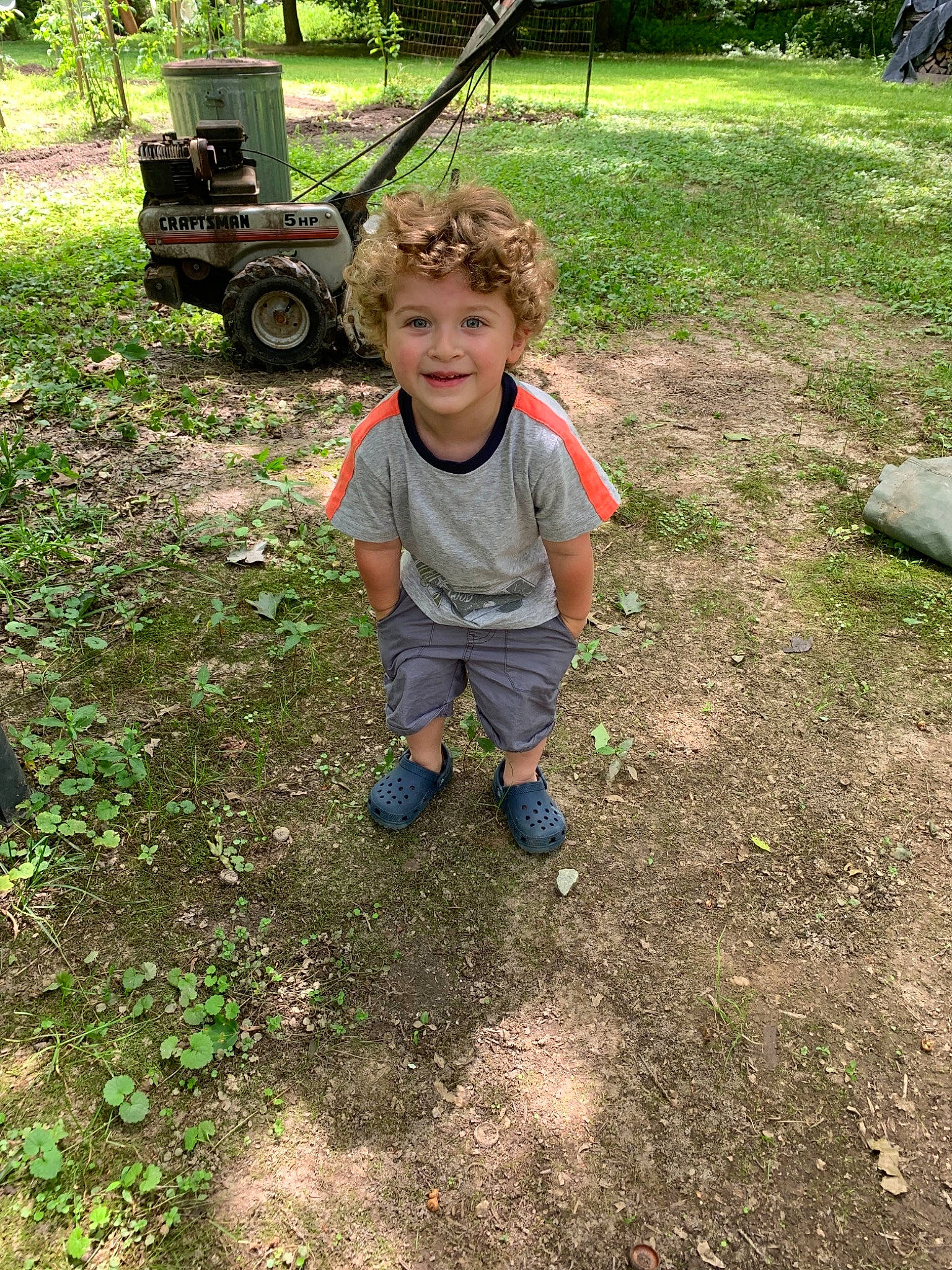 Koen is registered to the contest to win money with this photo: backyard, child, grass, headwear, joy, lawn, mud, person, plant, play, soil, toddler, tree, vehicle