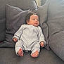 baby, infant, couch, cushion, gray, onesie, foot, hand, face, person, indoor, relaxing, cute, child, portrait, seated, soft, comfort, home, cozy