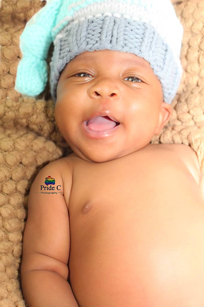 Tru is registered to the contest to win money with this photo: baby, cap, cheek, chin, eye, eyebrow, face, finger, happy, hat, head, headgear, headwear, human_body, lip, mouth, nose, organ, person, skin