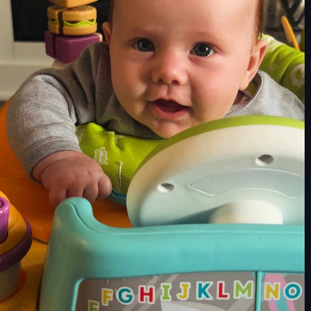 L-Jay is registered to the contest to win money with this photo: baby, blocks, child, closeup, clothing, colorful, cute, face, happy, indoor, infant, learning, person, play, playground, seat, smile, steering_wheel, toy, young