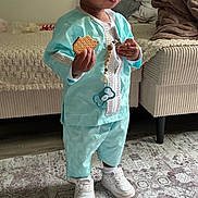 Issa a rejoint le concours — aidez-le/la à gagner de superbes lots ! baby, bed, blanket, blue_outfit, cheeks, child, cookie, curly_hair, cute, furniture, hand, indoor, pacifier, pacifier_clip, portrait, rug, sneakers, sofa, standing, toddler