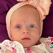 Lilou participe au concours pour gagner de l'argent avec cette photo : baby, infant, headband, bow, pink, blue_eyes, floral, dress, clothing, face, portrait, cute, child, skin, expression, person, laying, background, purple, closeup