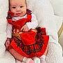 baby, infant, red_dress, reindeer, plaid, white_blanket, cozy, cute, smiling, tongue_out, child, socks, soft_texture, indoor, portrait, happy, holiday, festive, person, seated