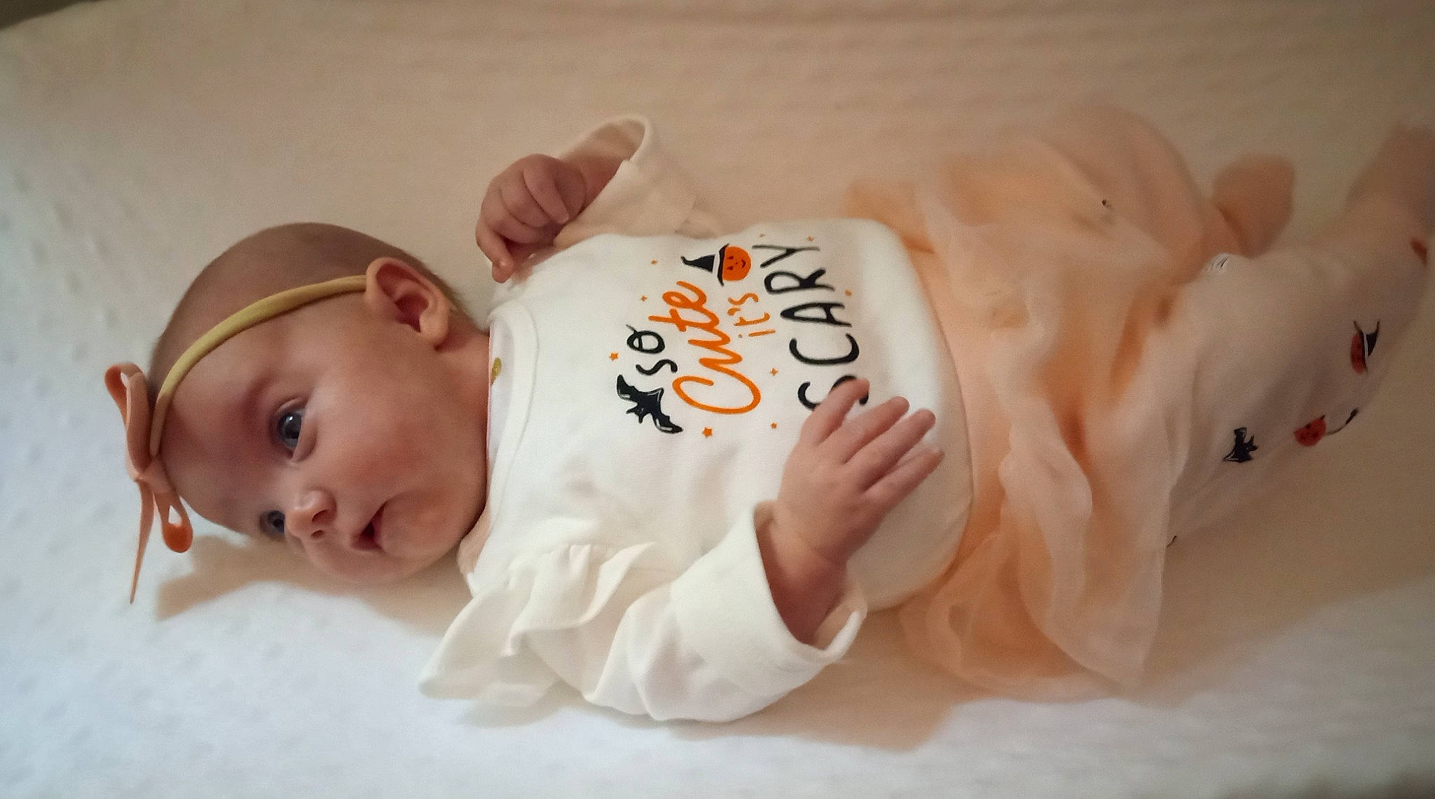 Lily May is registered to the contest to win money with this photo: abdomen, arm, baby, baby_toddler_clothing, cheek, child, comfort, eye, foot, hand, happy, hat, head, human_leg, person, room, skin, sleeve, toddler, toy