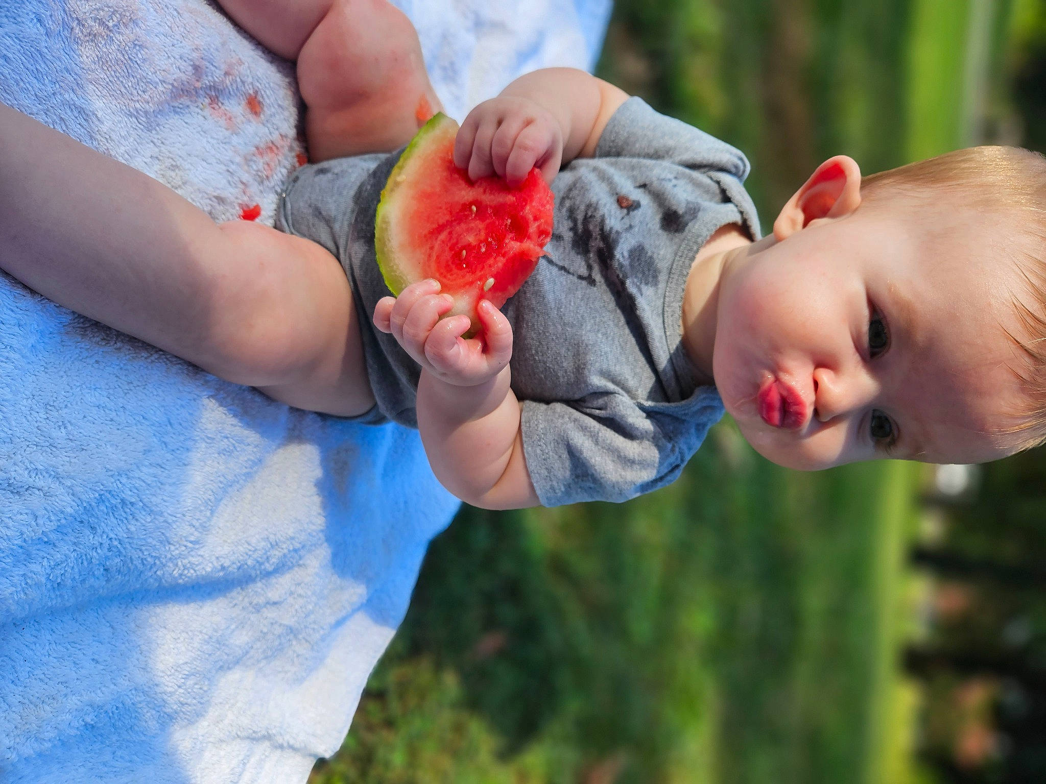 Gracie is registered to the contest to win money with this photo: arm, baby, ball, child, elbow, finger, fruit, fun, gesture, grass, happy, leisure, nail, people_in_nature, person, plant, recreation, t_shirt, thumb, toddler