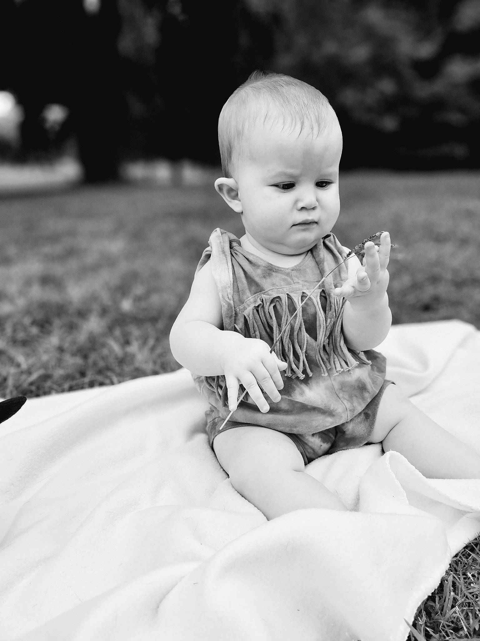 Gracie is registered to the contest to win money with this photo: baby, baby_toddler_clothing, black, black_and_white, eye, facial_expression, flash_photography, fun, gesture, grass, hand, happy, head, human_body, monochrome_photography, person, skin, standing, style, toddler