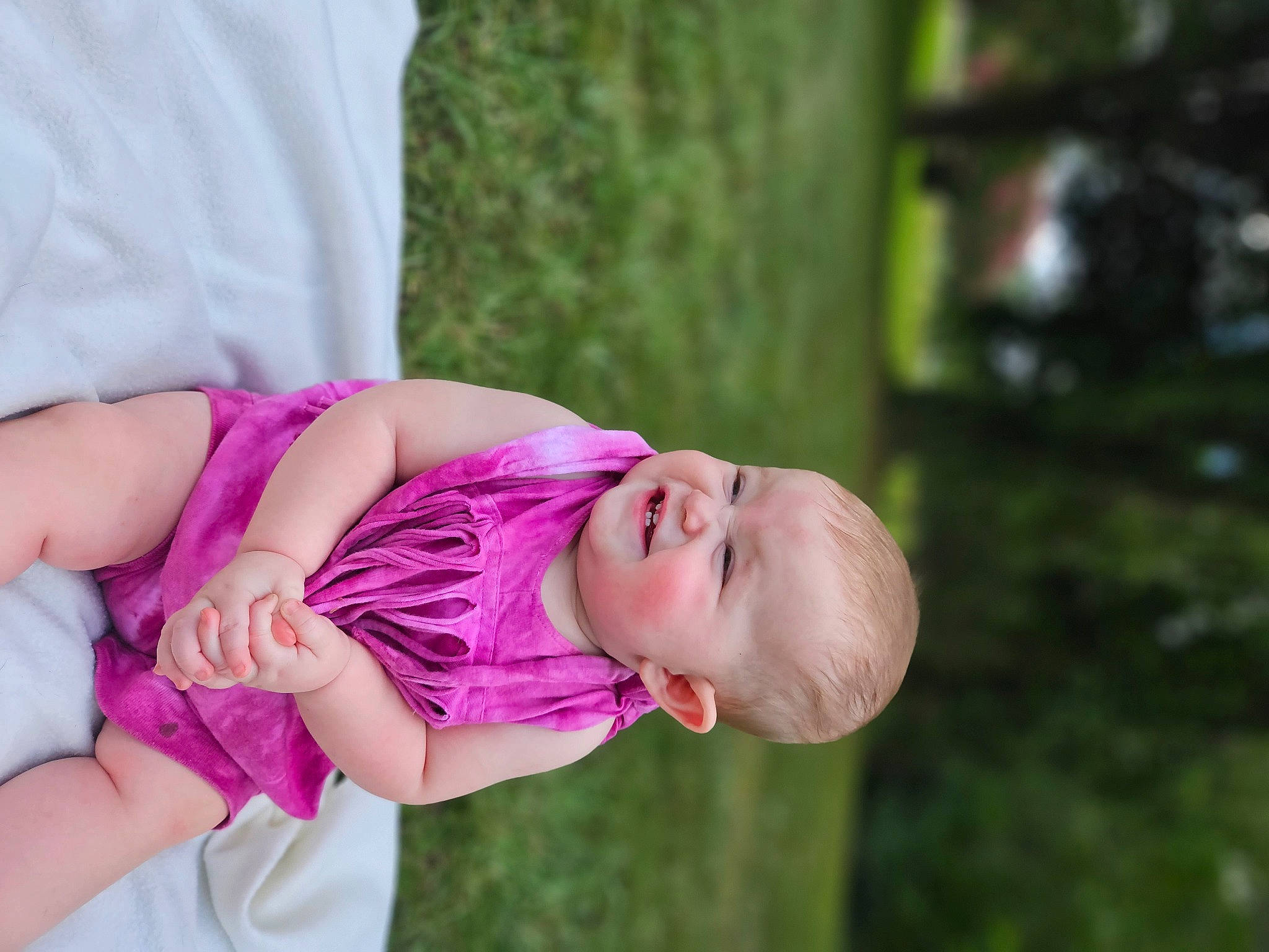 Gracie is registered to the contest to win money with this photo: baby, baby_toddler_clothing, child, dress, eye, finger, glasses, grass, happy, hat, human_body, leisure, magenta, person, pink, plant, sitting, skin, smile, toddler