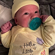 Haven is registered to the contest to win money with this photo: newborn, baby, infant, child, portrait, face, eyes, pacifier, hat, beanie, yellow_clothing, onesie, winnie_the_pooh, tigger, plush_blanket, lying_down, indoor, close_up, smiling, text_on_clothing