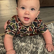 Reece joined the competition — help win amazing prizes! baby, child, crawling, carpet, floor, camouflage_shirt, drool, indoor, living_room, curious, hands, face, eyes, person, cute, toddler, plush, home, furniture, wood_floor
