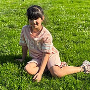 Alfiya participe au concours pour gagner de l'argent avec cette photo : child, girl, grass, outdoor, sunlight, casual, pink_clothing, shorts, tshirt, sneakers, smile, fringe_hair, nature, relaxing, greenery, daylight, portrait, kneeling, park, young