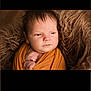 baby, blanket, brown, child, closeup, cozy, cute, face, fur, indoors, infant, newborn, peaceful, person, portrait, sleepy, soft_lighting, texture, warm_colors, wrapped
