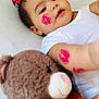 adorable, baby, child, cute, face_paint, indoors, infant, kiss_marks, love_heart, lying_down, person, playful, plush_toy, portrait, red_bow, red_color, skin, soft_toy, teddy_bear, white_shirt