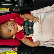 Rylann joined the competition — help win amazing prizes! baby, car_seat, child, infant, blanket, safety_harness, pink, smiling, cute, indoors, person, seat_belt, padding, clothing, head, arm, face, resting, happy, toddler