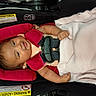 baby, car_seat, child, infant, blanket, safety_harness, pink, smiling, cute, indoors, person, seat_belt, padding, clothing, head, arm, face, resting, happy, toddler