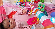 Rylann joined the competition — help win amazing prizes! baby, bright_colors, child, colorful, curious, cute, early_childhood, face, hand, indoor, infant, lying_down, pink_clothing, plastic_toys, play_mat, playtime, soft_mat, striped, toy, young_child