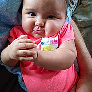 Rylann joined the competition — help win amazing prizes! baby, infant, child, cute, pink_clothing, chubby_cheeks, hands, face, portrait, resting, blanket, blue, pattern, human, skin, expression, indoor, person, holding, closeup