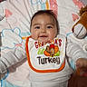 Rylann joined the competition — help win amazing prizes! baby, bedding, bib, blanket, child, cozy, crib, diaper, happy, indoor, infant, lion_toy, lying_down, nursery, onesie, plush_toy, portrait, smiling, thanksgiving, turkey
