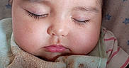 Rylann joined the competition — help win amazing prizes! baby, bed, blanket, cheeks, child, close_up, closed_eyes, crib, cute, face, indoor, infant, peaceful, photography, pink_clothing, portrait, resting, sleeping, star_pattern, swaddled