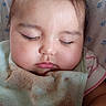 baby, sleeping, infant, portrait, face, closed_eyes, cheeks, blanket, swaddled, crib, bed, indoor, close_up, peaceful, resting, pink_clothing, star_pattern, photography, cute, child