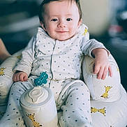 Billy-James joined the competition — help win amazing prizes! baby, child, infant, smile, face, pajamas, star_pattern, giraffe_pattern, cushion, seat, indoor, comfort, relaxed, cute, person, small_hand, soft_lighting, portrait, happy, clothing
