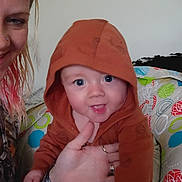 Kash joined the competition — help win amazing prizes! baby, child, hoodie, woman, indoor, smiling, person, hand, face, cushion, pattern, colorful, seated, clothing, skin, hair, holding, happy, portrait, casual