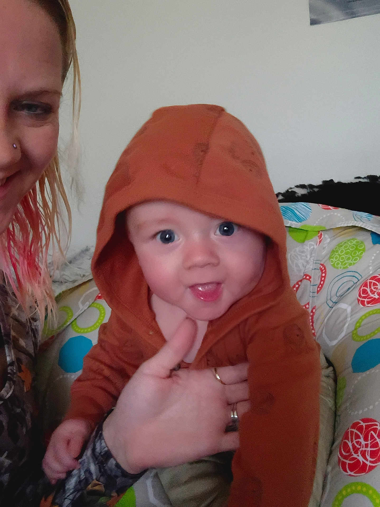 Kash joined the competition — help win amazing prizes! baby, child, hoodie, woman, indoor, smiling, person, hand, face, cushion, pattern, colorful, seated, clothing, skin, hair, holding, happy, portrait, casual