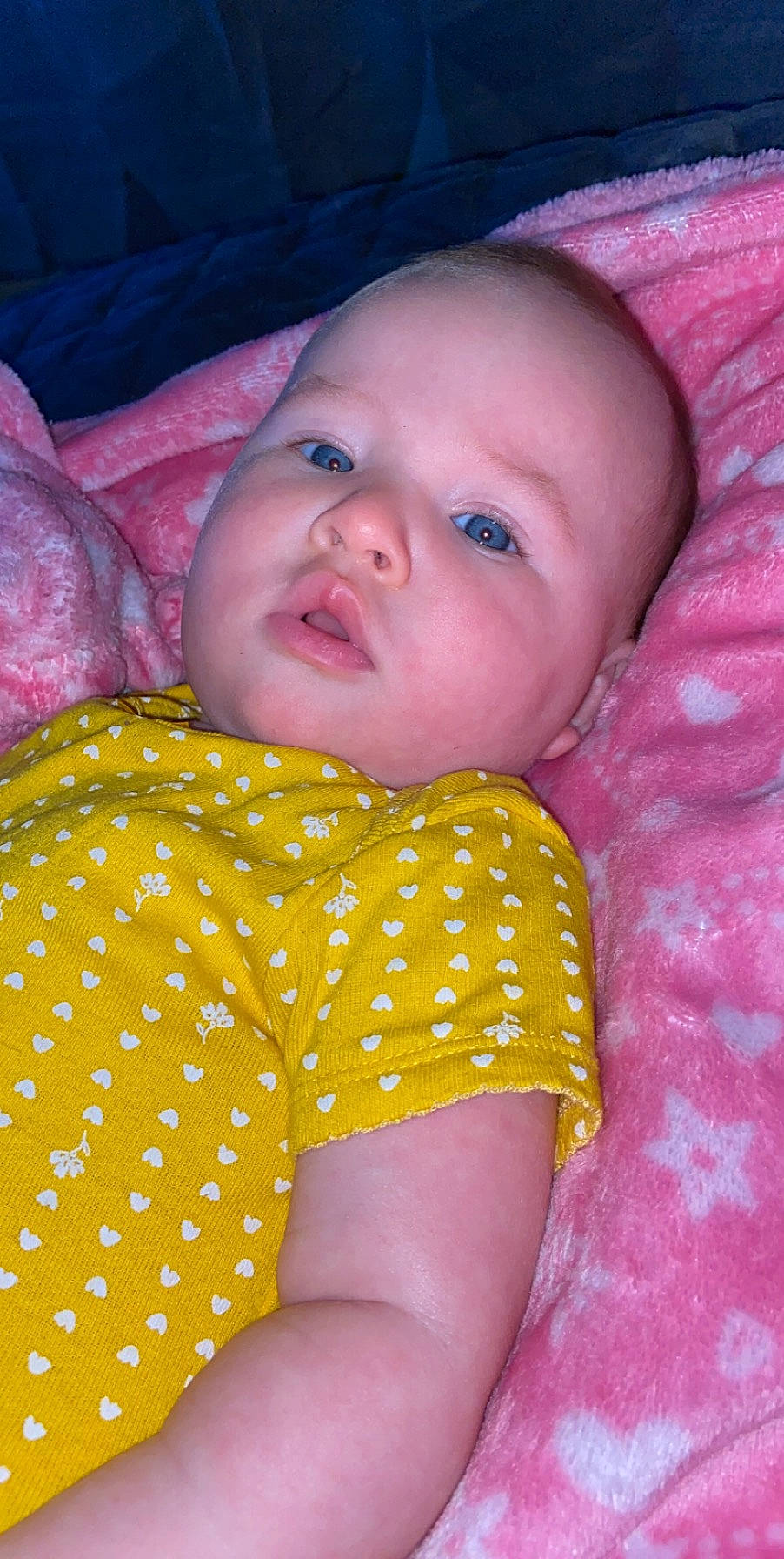 Astrid is registered to the contest to win money with this photo: baby, cheek, child, eye, face, head, iris, lip, mouth, nose, pattern, person, pink, skin, smile, textile, toddler, yellow