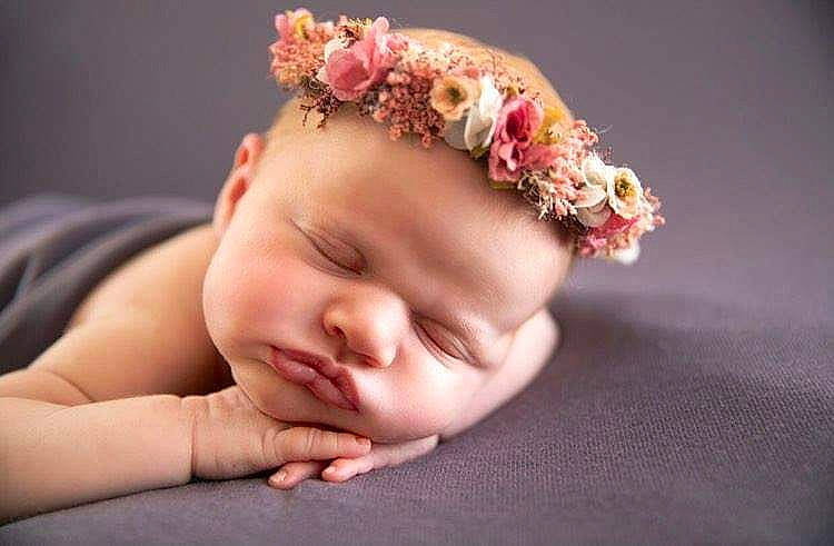 Emery is registered to the contest to win money with this photo: baby, baby_toddler_clothing, chin, comfort, dress, ear, eye, eyebrow, eyelash, finger, flash_photography, gesture, hair, hand, happy, head, lip, neck, person, petal