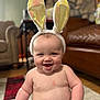 Levi joined the competition — help win amazing prizes! baby, bunny_ears, diaper, smiling, sitting, indoor, carpet, living_room, furniture, couch, stone_wall, child, cute, happy, infant, headwear, person, plush, skin, home