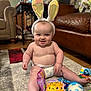 Levi joined the competition — help win amazing prizes! baby, bunny_ears, diaper, toys, carpet, smiling, indoor, child, cute, playtime, happy, floor, colorful, infant, couch, furniture, headwear, cheerful, person, home