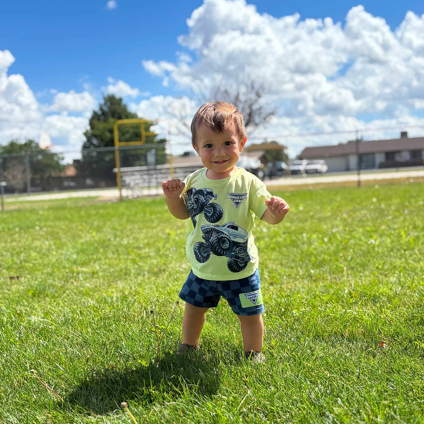 Romyn is registered to the contest to win money with this photo: child, boy, toddler, smiling, outdoor, grass, playground, park, sunny, clouds, blue_sky, portrait, standing, shorts, t_shirt, sportswear, happy, daylight, residential_area, photography
