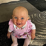 Beau is registered to the contest to win money with this photo: baby, blue_eyes, carpet, child, clothing, cute, expression, face, floor, hand, happy, indoors, infant, person, pink_dress, playful, sitting, smiling, tights, toddler