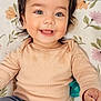 Aaliyah joined the competition — help win amazing prizes! baby, blue_eyes, child, closeup, clothing, cushion, cute, face, floral_pattern, hair, hand, happy, indoor, infant, lying_down, pants, portrait, skin, smiling, sweater