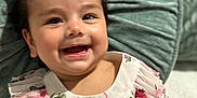 Aaliyah joined the competition — help win amazing prizes! baby, bow, child, clothing, cushion, cute, face, floral_dress, girl, green, hair_accessory, happy, indoors, infant, person, pillow, portrait, skin, smiling, young