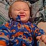 Abel is registered to the contest to win money with this photo: baby, blanket, blue, child, cozy, cute, face, happy, holding, indoor, infant, joy, onesie, orange, patterned_clothing, person, playful, quilt, slipper, smiling