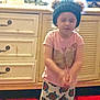 Alora joined the competition — help win amazing prizes! child, indoor, hat, pink_shirt, butterfly, patterned_pants, cabinet, furniture, floor, red_cushions, black_hat, pom_poms, standing, young_child, clothing, person, home, casual, expression, motion_blur