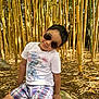 bamboo, boy, casual, child, dinosaur, forest, leaves, nature, outdoor, plants, playful, rock, shade, shorts, smile, summer, sunglasses, sunlight, trees, tshirt