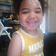 Malakai joined the competition — help win amazing prizes! toddler, child, smiling, yellow_shirt, cream_on_face, cream_on_arm, indoor, high_chair, furniture, happy, person, portrait, curly_hair, playful, closeup, casual_clothing, home, daylight, expression, cute