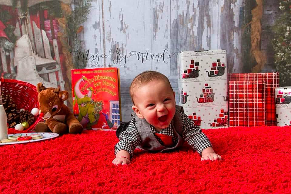 Jakobe is registered to the contest to win money with this photo: carpet, child, christmas, christmas_decoration, flooring, fun, grass, holiday, infant, person, plant, play, product, recreation, red, textile, toddler