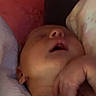 newborn, baby, infant, sleeping, face, portrait, indoors, bed, pillows, blanket, resting, lying_down, hand, closed_eyes, mouth_open, cozy, home, soft_lighting, close_up, child