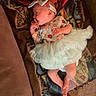 Penelope is registered to the contest to win money with this photo: baby, infant, sleeping, tutu, dress, headband, portrait, face, hand, finger, blanket, couch, cushion, textile, indoor, cozy, colorful, lying_down, barefoot, family_photo