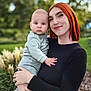 Lyam participe au concours pour gagner de l'argent avec cette photo : baby, woman, child, outdoor, nature, greenery, plants, portrait, holding, casual_clothing, red_hair, blue_eyes, smile, family, tender_moment, grass, flowers, long_sleeve, jeans, baby_clothes