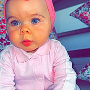 Zoony participe au concours pour gagner de l'argent avec cette photo : adorable, baby, blue_eyes, child, closeup, colorful_pillow, cozy, cute, face, hands, headband, indoor, infant, person, pink_bow, pink_outfit, portrait, sitting, soft_lighting, young_child